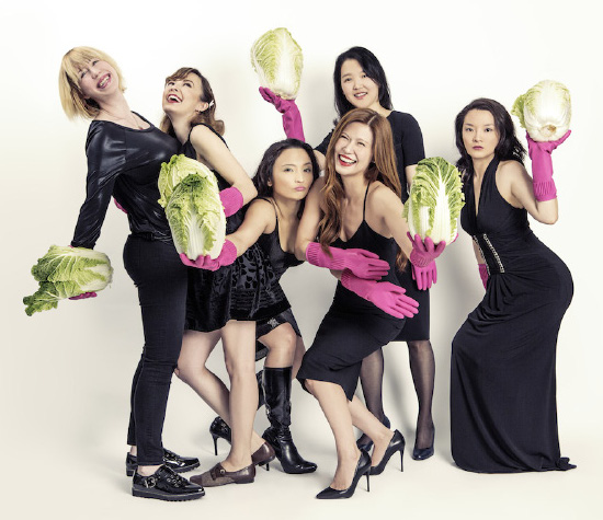 The Crazy Korean Cooking team laughing and holding cabbages